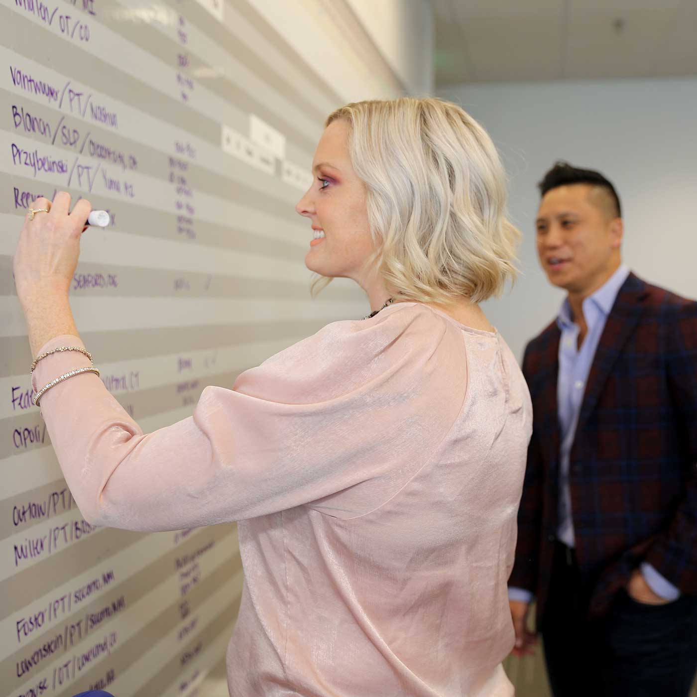 Penny writing on a whiteboard at The Delta Companies